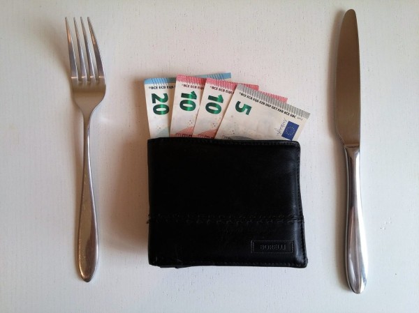 How to save money for travel - set a budget - money in wallet 