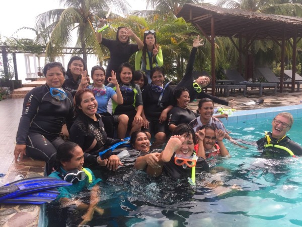 Group of divers laughing in a pool