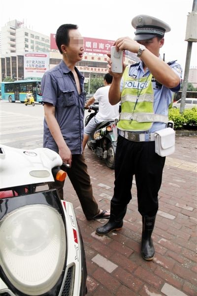 交警用警务通查询电动车的信息。图片来源：当代生活报