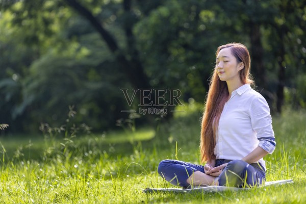 女人在森林中放松地练习冥想，从内心的平静中获得幸福，为健康的心灵和灵魂获得智慧照片摄影图片