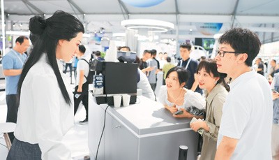 观众在2024云栖大会前沿应用展馆与人形机器人互动。 新华社记者 黄宗治摄