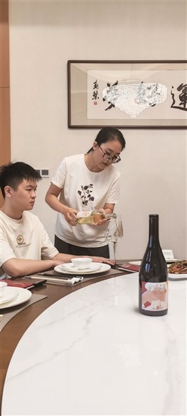  李引弟边倒酒边讲解宁夏葡萄酒的品质特点。