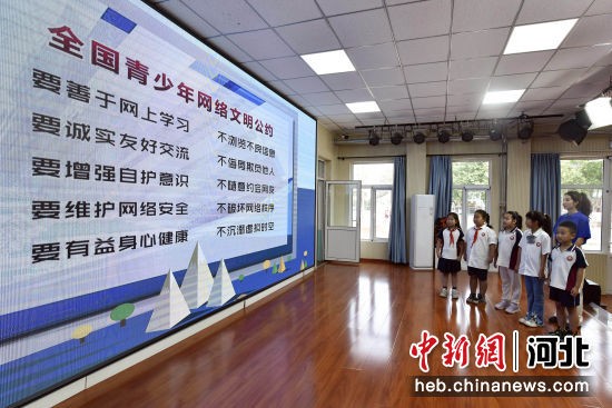 图为廊坊市第十三小学，广阳区委网信办的志愿者与学生代表一同宣读全国青少年网络文明公约。 付瑞琪 摄