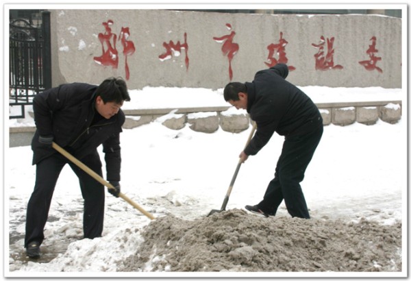 我委组织职工清扫门前的积雪