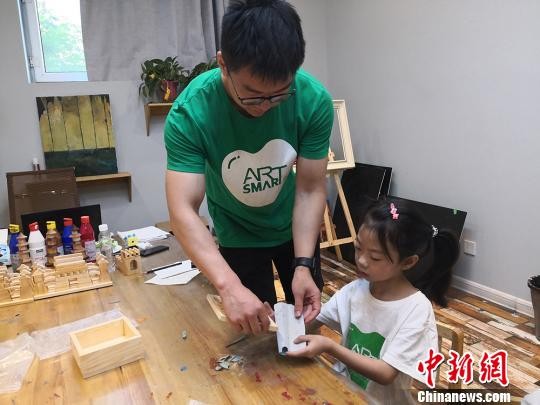 图为老师正在给学生手把手引导教学。　高康迪 摄