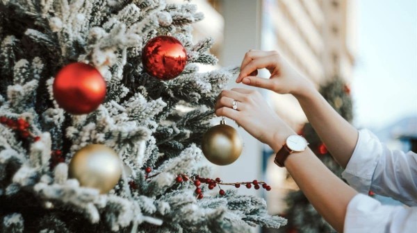 mujer decora árbol de Navidad