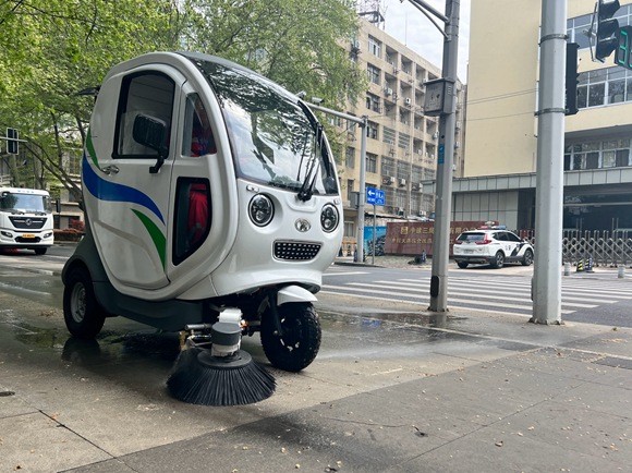 一小型电动“单兵清扫车”在清理落絮。曈暚摄