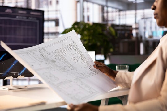 Architect drawing construction blueprint after researching and analyzing building codes and zoning regulations. Close up of woman getting ready to present design concepts to clients