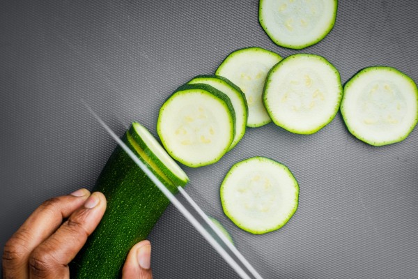 persona cortando en rodajas un pepino