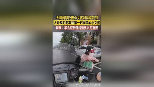 大哥骑摩托被女孩闯马路吓到 大哥及时刹车并第一时间关心小女孩