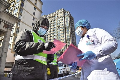 一位心理科医生（右）在给小区执勤人员分发心理健康宣传资料。新华社发