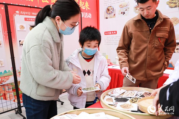 市民辨别“八珍药膳”所需中药材，参与互动。人民网 陈永整摄