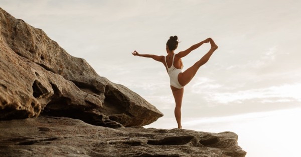 Una mujer haciendo yoga en la playa