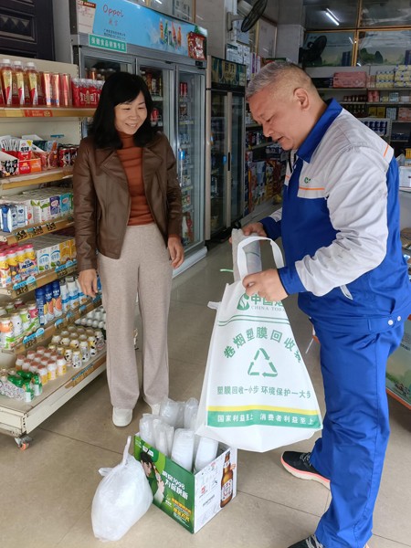 崇左烟草配送员将零售户的卷烟塑膜归集到回收袋。梁都勤摄