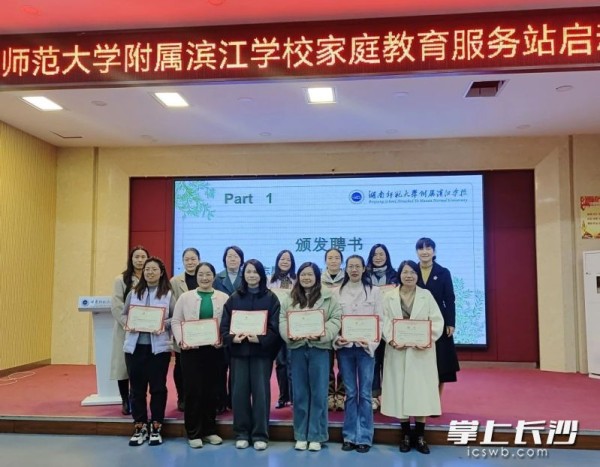向家庭教育服务站成员颁发聘书。