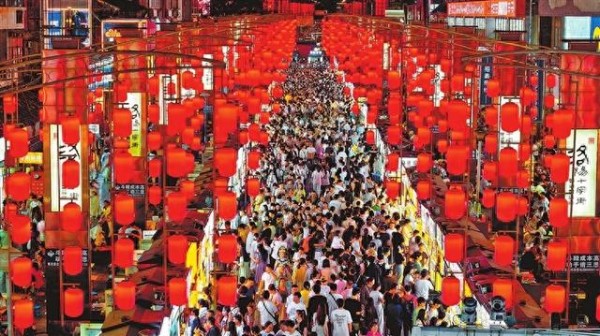 5月1日,夜幕降临,洛阳市老城区十字街上人潮涌动,游客们穿梭其间,品味着洛阳地道的传统美食,热闹非凡。王宏欣 摄