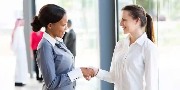 two women shaking hands