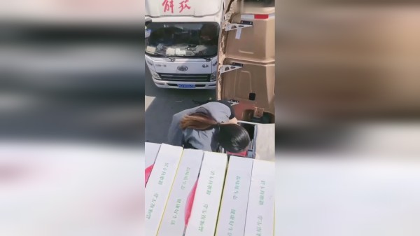 满满一车蔬菜装好，卡车女司机爬车厢盖布封顶，动作灵活干活麻利