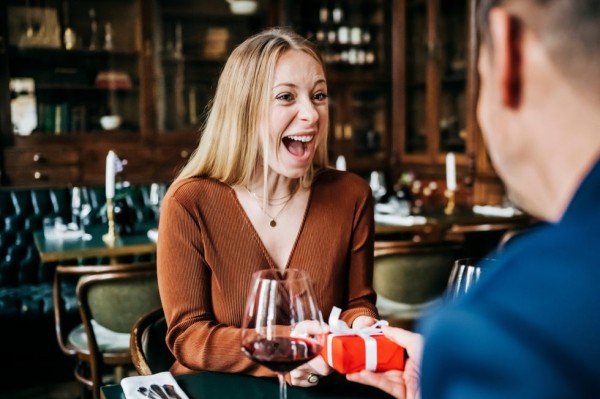 woman excited to receive gift in restaurant