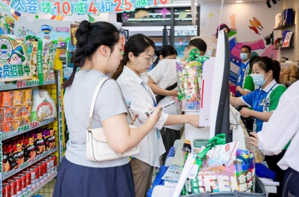 顾客在自助收银机前有序结账。