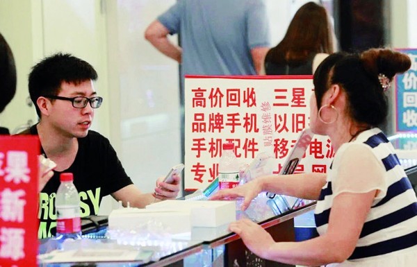 一名消费者在手机交易市场内咨询手机回收业务。新华社发