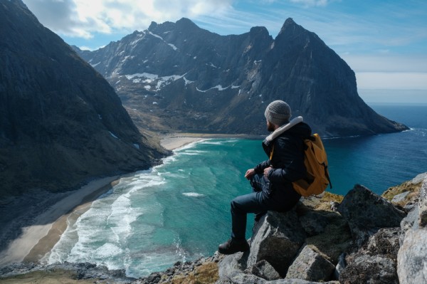 Solo Man Traveler Standing in Cliff in Norway - Solo Trip Packing List