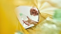 低角度视角：一个女孩将一个瓶子扔进塑料袋中 