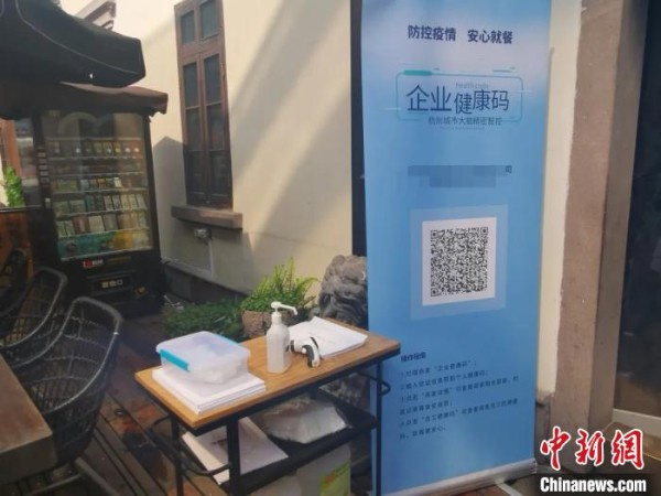 餐馆门口摆放“企业健康码”。 胡亦心 摄