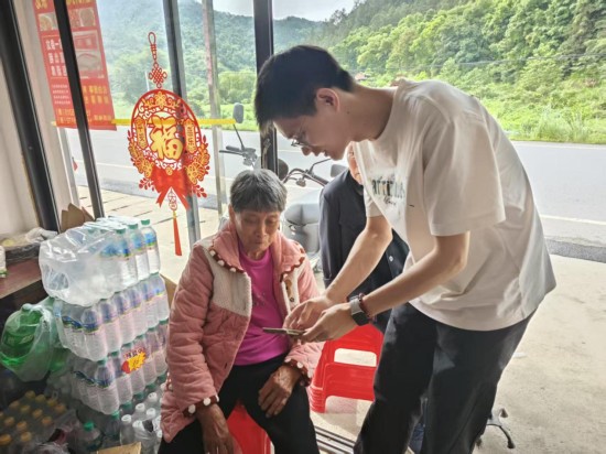 图为志愿者走访留守老人家中传授“三句半”