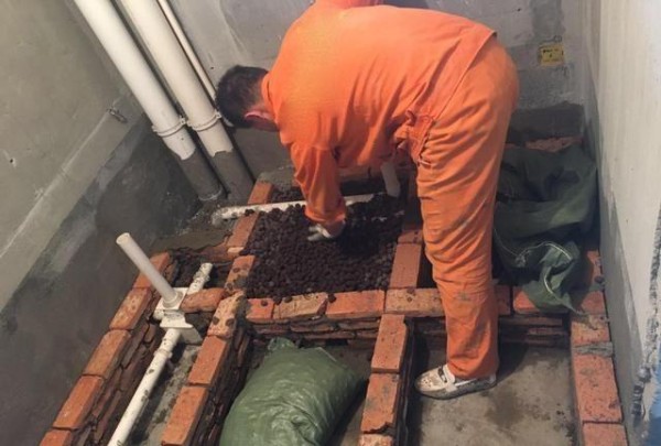 卫生间回填层红砖砌得整整齐齐，老师傅都知还要打个孔