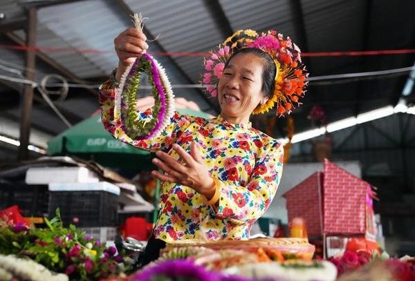 蟳埔女在市场上选购“簪花围”使用的鲜花。(新华社记者 刘琼 摄)