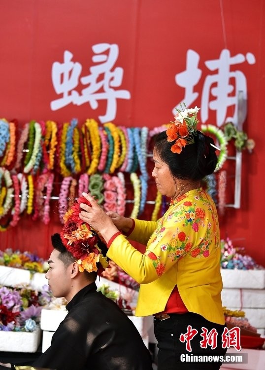 蟳埔女在为游客“簪花围”。(中新社记者 张斌 摄)
