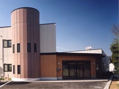 バリアフリー仕様のエントランスがある、ツートンカラーの建物