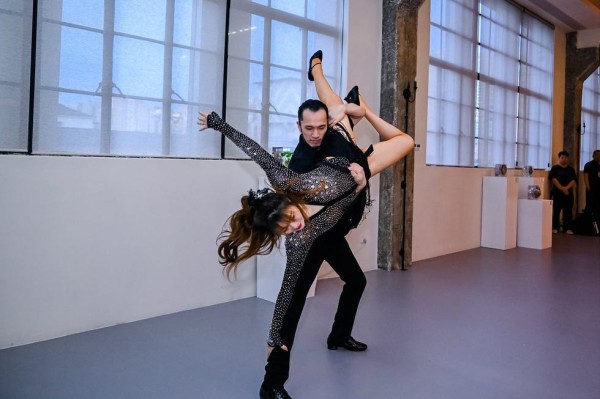 a couple performing a dance routine in a spacious venue