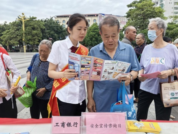 银行工作人员给老年客户宣传金融安全相关知识。