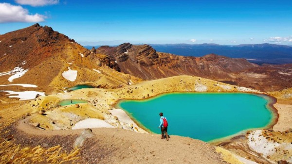 令人敬畏的火山景观 火山地区的壮丽全景,一位徒步旅行者正在欣赏美景。