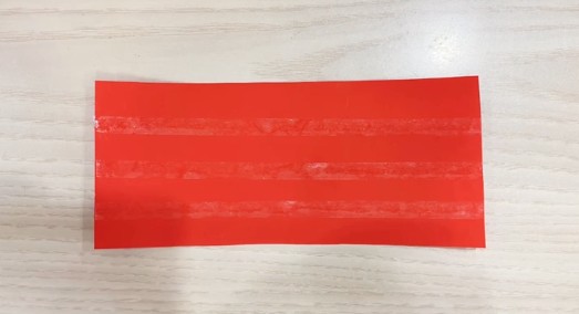 步骤3：大红色长方形卡纸贴3条双面胶。