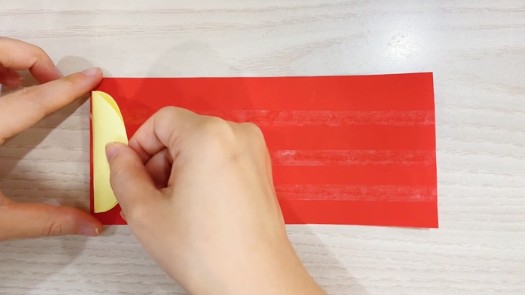 步骤4：圆片对折后贴在双面胶上。