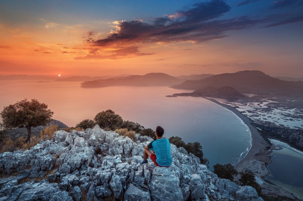 Solo Traveller Looking at Sunset on Mountain and Sea View - Solo Travel Tips