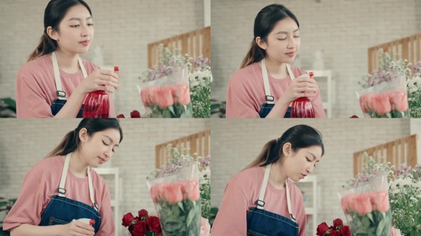都市园艺的乐趣:快乐的亚洲妇女在当地花店照料五颜六色的花朵。