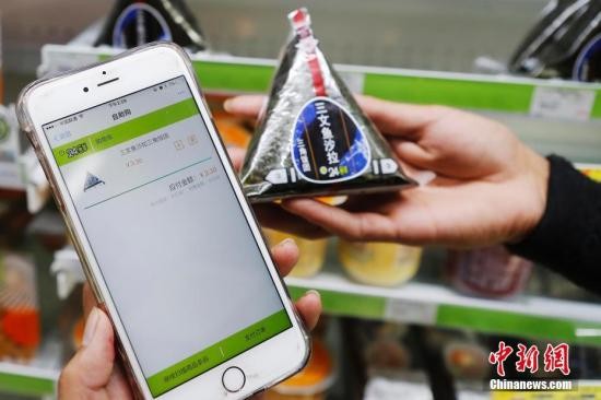 资料图：扫描商品条形码，使用手机自助结账后直接可以离开。 殷立勤 摄