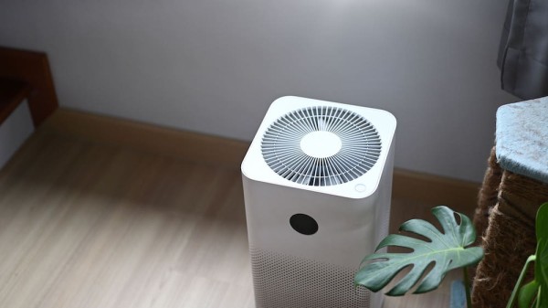 一部白色家用空氣清新機放在木地板上,使用設備過濾甲醛與提升室內空氣質素,是一種新流行的除甲醛方法