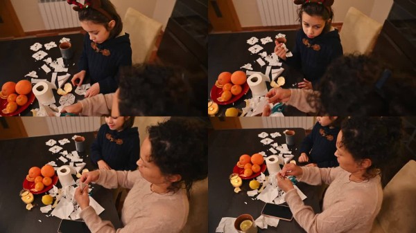 年轻孩子在圣诞准备期间与父母一起制作节日装饰品。
