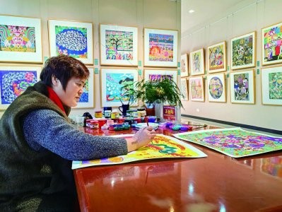 王金凤正在创作蛇年主题作品《灵蛇献瑞》。南京日报/紫金山新闻记者 孙敬清 摄