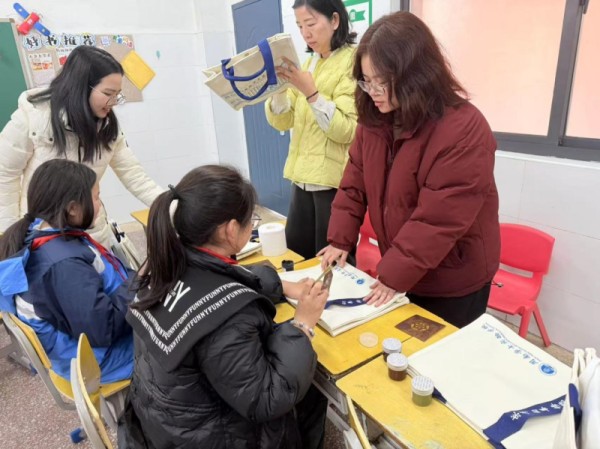 几名学生在老师指导下进行帆布包设计。