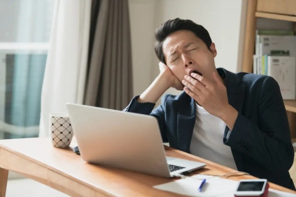 眠そうにしている男性 