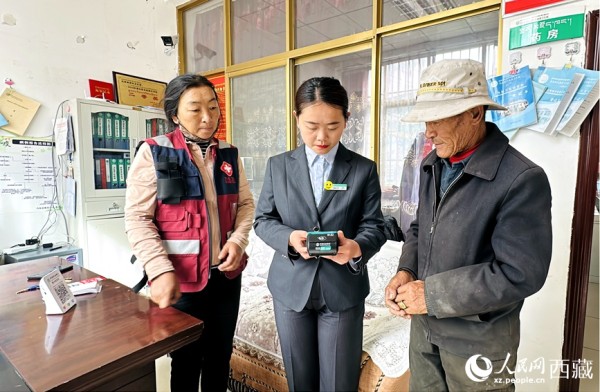 农行乃东支行客服经理伍思琪（右二）在为群众提供金融服务。人民网记者 次仁罗布摄
