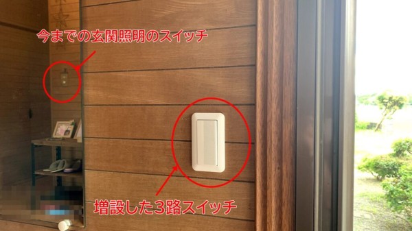 増設した3路スイッチと、鏡に映った今までの玄関照明スイッチ