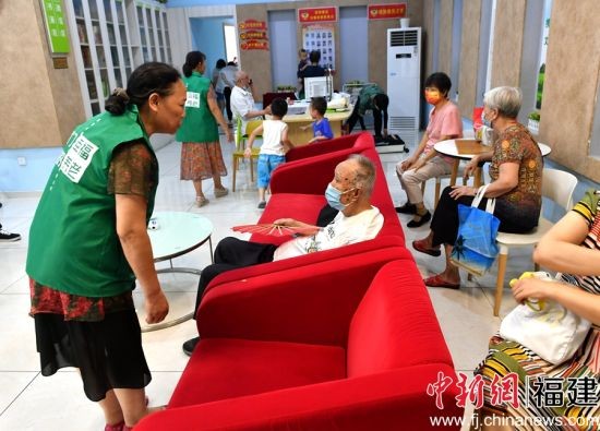  图为志愿者在社区活动室服务老年居民。吕明 摄