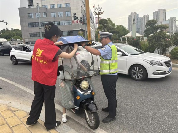 青年员工协助交警开展文明交通劝导。
